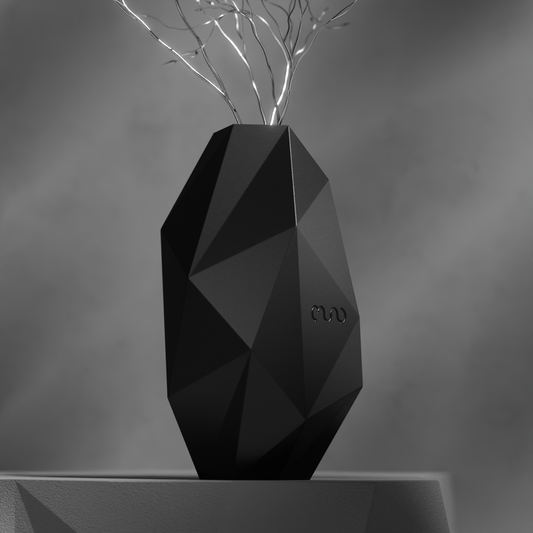 a black faceted vase with each facet reflecting light differently